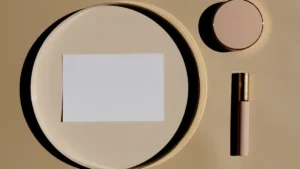 Beige and brown makeup products including lipstick and eyeshadow on a marble surface.