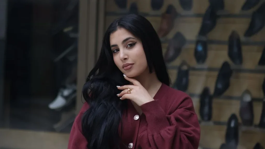 Close up profile of a woman wearing chocolate brown clothing and burgundy accessories.