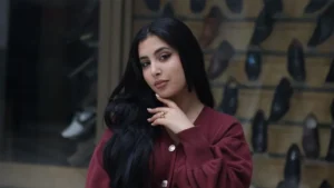 Close up profile of a woman wearing chocolate brown clothing and burgundy accessories.