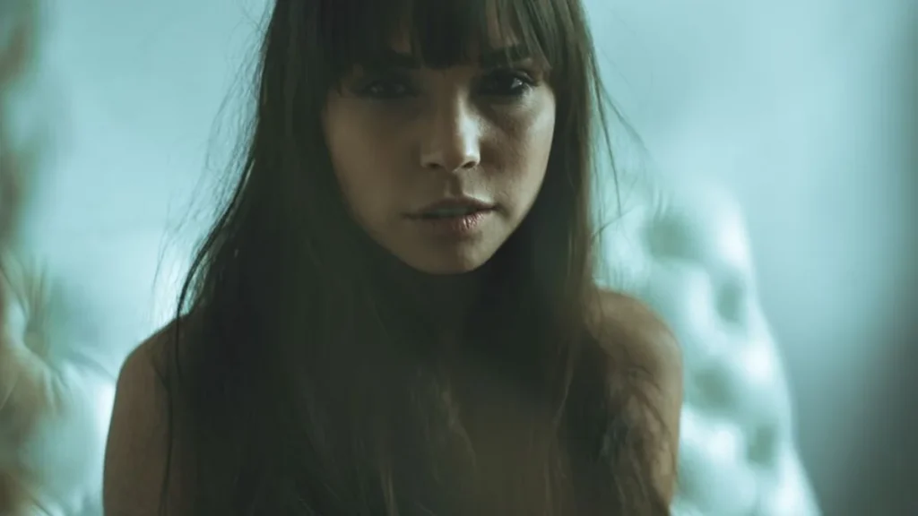 Two women with matching dark hair and identical bangs looking forward with serious expressions.